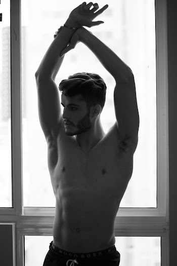 Grayscale Photo of Topless Man Stretching