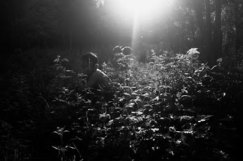 Grayscale Photo of Topless Man Surrounded by Plants
