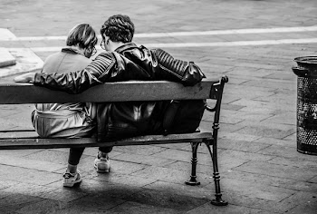 Grayscale Photo of Two Person Sitting on a Bench
