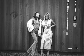 Grayscale Photo of Two Women Standing Near Shipping Container