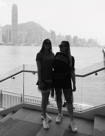 Grayscale Photo of Two Women Standing on Stairs