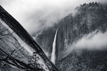grayscale photo of waterfalls with fogs