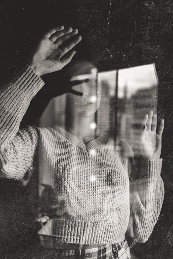 Grayscale Photo of Woman Behind Glass Panel