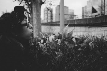 Grayscale Photo of Woman Blowing Leaves