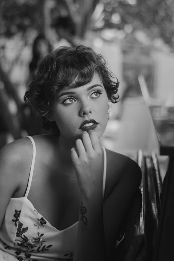 Grayscale Photo of Woman Holding Her Chin