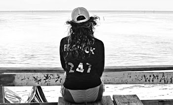 Grayscale Photo of Woman in Bikini Sitting on Table