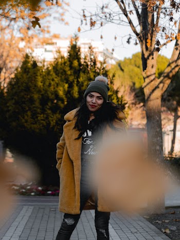 Grayscale Photo of Woman in Brown Coat Wearing Black Knit Cap