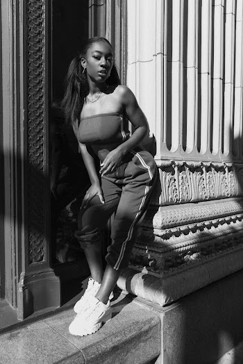 Grayscale Photo of Woman Leaning on Concrete Wall Posing