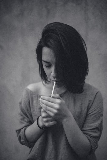 Grayscale Photo of Woman Lighting Cigarette