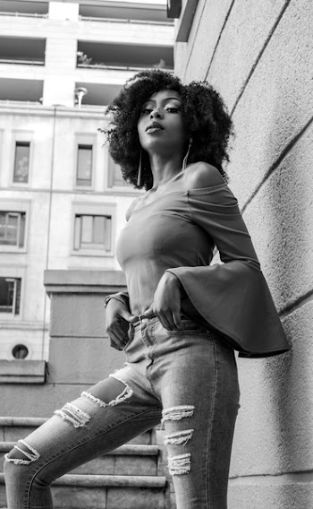 Grayscale Photo of Woman Posing Beside the Wall