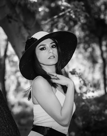Grayscale Photo of Woman Posing While Holding Her Neck