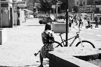 Grayscale Photo of Woman Sitting Near Bicycle