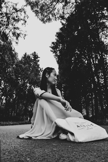 Grayscale Photo of Woman Sitting on Asphalt Raod