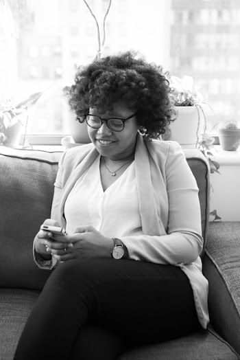 Grayscale Photo of Woman Sitting on Couch