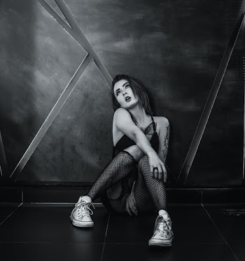 Grayscale Photo of Woman Sitting on Floor Tiles