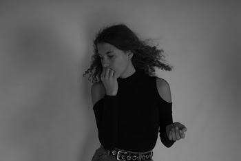 Grayscale Photo of Woman Standing in Front of Wall