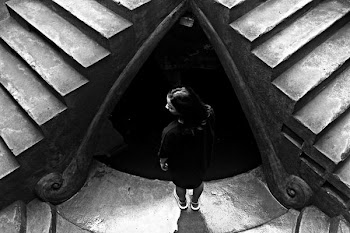 grayscale photo of woman standing near stairs