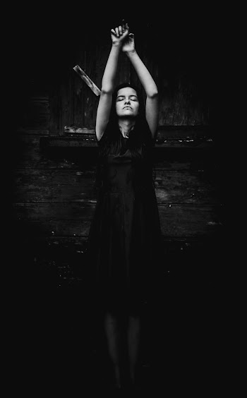 Grayscale Photo of Woman Standing With Her Hands Up and Her Eyes Closed