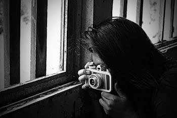 Grayscale Photo of Woman Taking Photo Beside Window