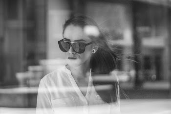 Grayscale Photo of Woman through a glass window
