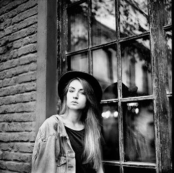 Grayscale Photo of Women's Denim Jacket and Hat Leaning on Window