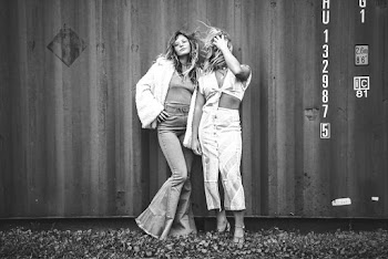Grayscale Photo of Women Posing Against Shipping Container