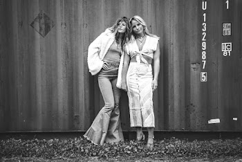Grayscale Photo of Women Posing Against Shipping Container