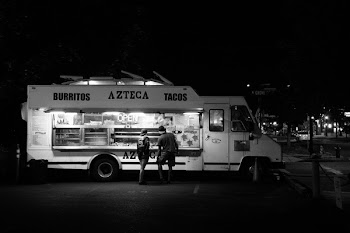 Grayscale Photograph of Two People Standing in Front of Food Truck