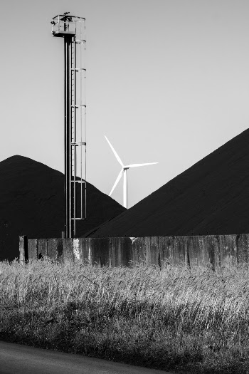 Grayscale Photography of a Wind Mill Behind Mountains