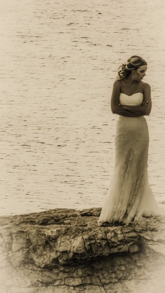 Grayscale Photography of a Woman Standing on Cliff Near Sea