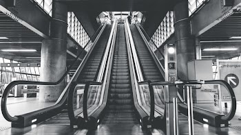 Grayscale Photography of Airport Escalators