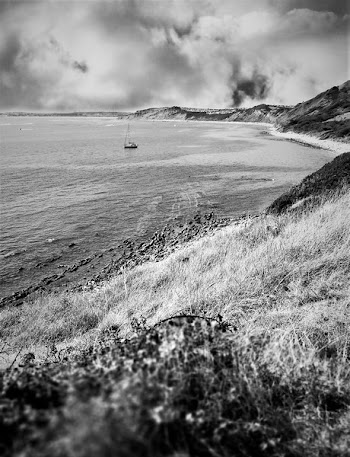 Grayscale Photography of Boat on Body of Water Near Mountain