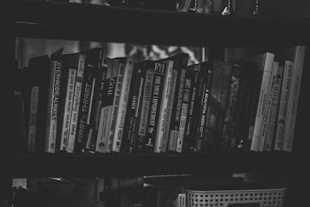 Grayscale Photography of Books Stacked in Shelf
