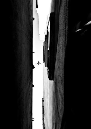 Grayscale Photography of Building and Airplane on Skies