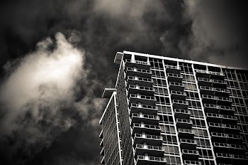 grayscale photography of building under cloudy sky