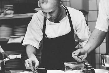 grayscale photography of chef preparing dish