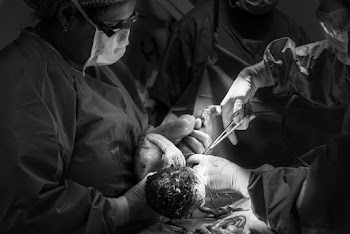 Grayscale Photography of Doctor Carrying Baby