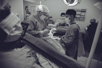 Grayscale Photography of Doctor Holding Baby