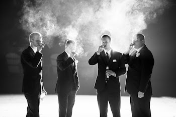 Grayscale Photography of Four Men Smoking While Standing