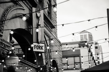 Grayscale Photography of Light Bulbs Near Concrete Buildings