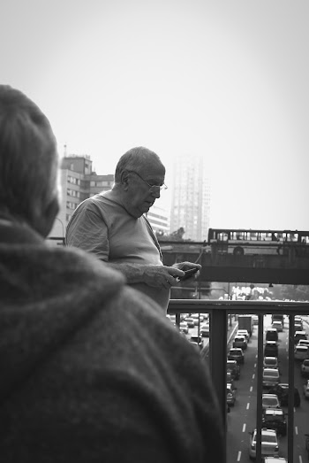 Grayscale Photography of Man Holding Smartphone