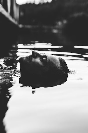 grayscale photography of man in body of water