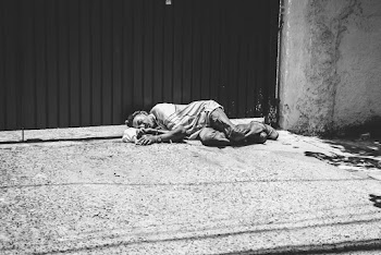 Grayscale Photography Of Man Lying Beside Gate