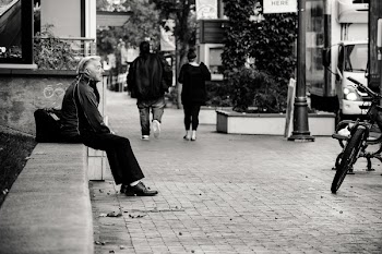Grayscale Photography of Man Sitting on Bench