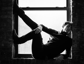 Grayscale Photography of Man Sitting on Window Pane