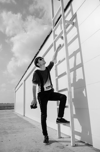 Grayscale Photography of Man Standing Beside Ladder