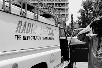 Grayscale Photography of Man Standing Beside Utility Truck