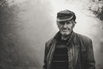 Grayscale Photography of Man Wearing Cap and Jacket