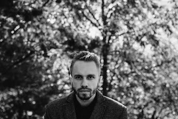 Grayscale Photography of Man Wearing Coat Near Trees