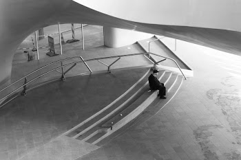 Grayscale Photography of Man Wearing Shirt Wile Sitting on Stair